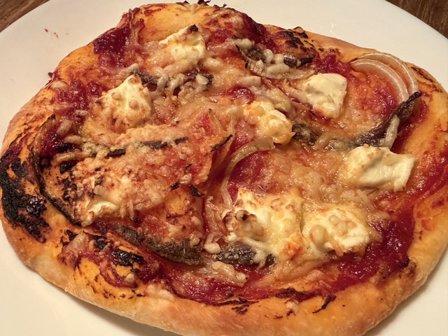 Fertig gebackene Pizza aus der Heißluftfritteuse mit Sardellen und Brie